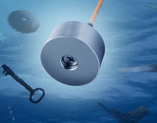 Neodymium vismagneet aan oranje touw onder water, trekt metalen objecten zoals sleutel en zaagblad omhoog bij magneetvissen.