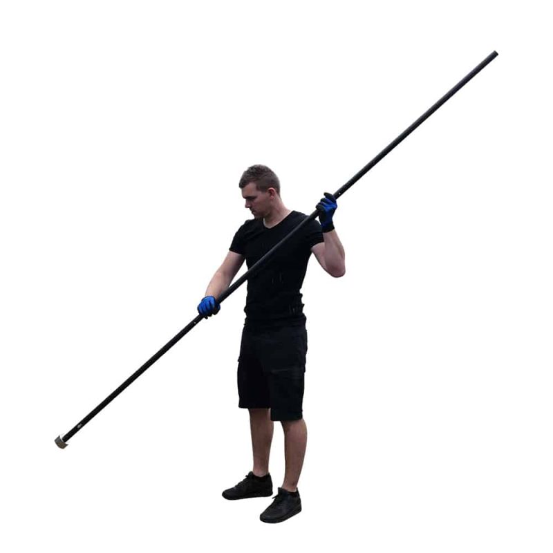 Lifestylefoto van man in zwarte outfit met blauwe werkhandschoenen die een lange aluminium prikstok met vismagneet vasthoudt.
