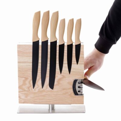 Houten magnetisch messenblok met zes keukenmessen en geïntegreerde messenslijper, hand toont gebruiksgemak bij slijpen.