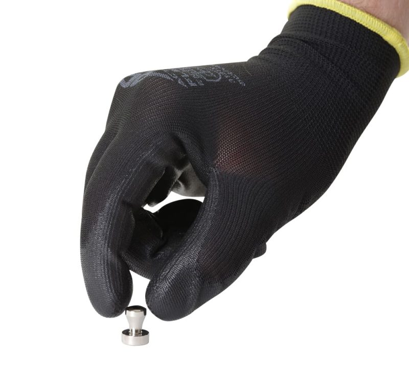 Detailfoto van een hand met zwarte werkhandschoen die een kleine neodymium pionmagneet vasthoudt voor gebruik op metalen oppervlakken.