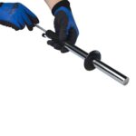 Uitschuifbare magneetstaaf met zwart handvat, vastgehouden met werkhandschoenen, handig voor het oppakken van metalen objecten.