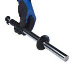 Hand met blauwe werkhandschoen die een uitschuifbare magneetstaaf met zwart handvat vasthoudt, ideaal voor metaaldetectie.